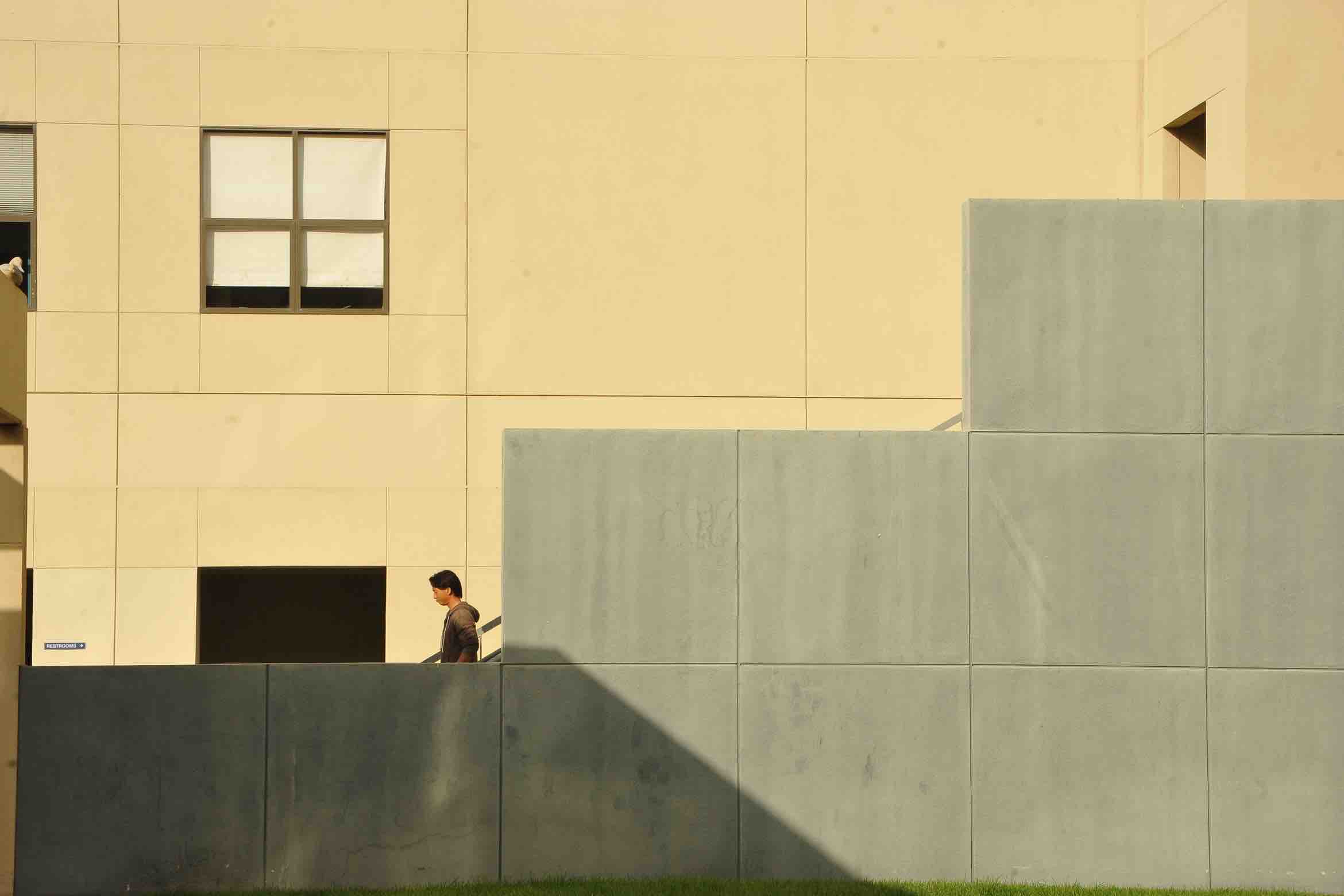 student walking down building stairs partially hidden